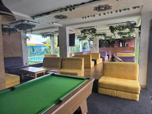 a billiard room with a pool table and chairs at Trev Hotels and Suites in Asaba