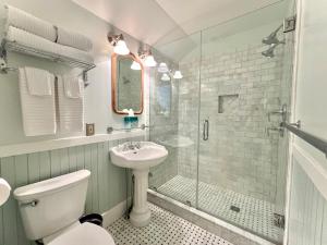 a bathroom with a toilet and a sink and a shower at The Interlaken Inn in Lake Placid +18 photos