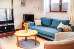 a living room with a blue couch and a table at FeWo Adele ruhige Auszeit am Dümmersee in Hüde