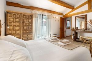 a bedroom with a white bed with towels on it at Le Mas de la Rode in Saumane