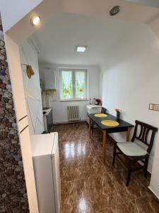 a kitchen and dining room with a table and chairs at Apartament Iasmina 2 in Petroşani +7 photos