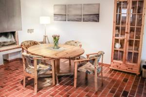 a dining room table with chairs and a vase of flowers at FeWo Adele ruhige Auszeit am Dümmersee in Hüde