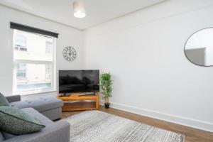 a living room with a couch and a tv at Central Stroud 3-Bedroom Flat with Fast WiFi in Stroud