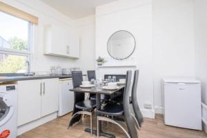 a kitchen with a table with chairs and a mirror at Central Stroud 3-Bedroom Flat with Fast WiFi in Stroud