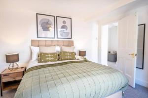 a bedroom with a large bed with two green pillows at Central Stroud 3-Bedroom Flat with Fast WiFi in Stroud