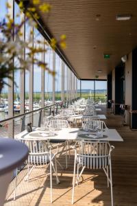 a row of white tables and chairs on a balcony at Neueröffnung NEUER STRAND inklusive Burgenland Card in Breitenbrunn