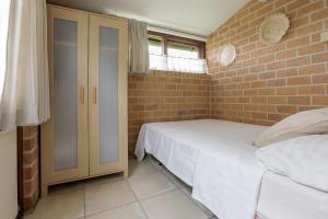 a bedroom with two beds and a brick wall at Rekerlanden 187 in Schoorldam