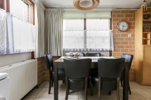a dining room with a table and chairs and a clock at Rekerlanden 187 in Schoorldam +18 photos