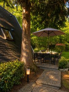 a table with an umbrella next to a tree at Chalet in Le Tholy