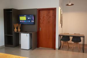 a room with a door and a table and a television at Pousada Villa Ricca Park in Niquelândia