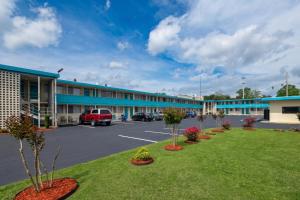 a large building with a parking lot in front at Carolina Inn Anderson Clemson Area in Anderson