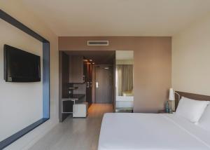 a bedroom with a large white bed and a bathroom at Hotel Spa Mediterráneo Park in Roses