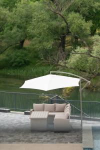 a white couch under an umbrella on a patio at Villa H in Blagaj