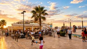 a crowd of people walking around a beach at sunset at Casa Lovely in Daimuz