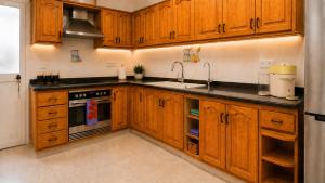 a kitchen with wooden cabinets and a sink at Casa Lovely in Daimuz