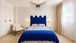 a bedroom with a blue bed and a chair at Casa Lovely in Daimuz +19 photos