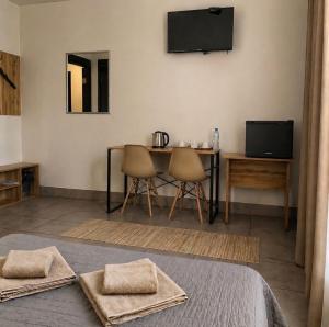 a room with a table and chairs and a television at Mia Hotel in Rivne