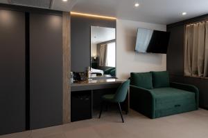 a hotel room with a green chair and a desk at Житомир by Optima in Zhytomyr