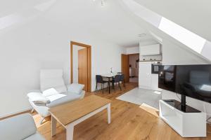 a living room with a white couch and a tv at Stiftblick Residence Melk in Melk