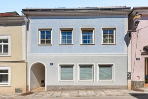 a blue building with white windows on a street at Stiftblick Residence Melk in Melk