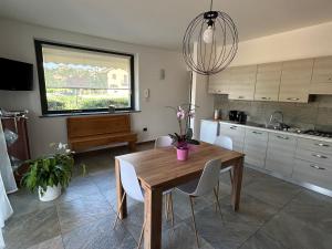 a kitchen with a wooden table and white chairs at Ca Sofia in Cervere