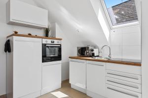 a kitchen with white cabinets and a sink at Stiftblick Residence Melk in Melk