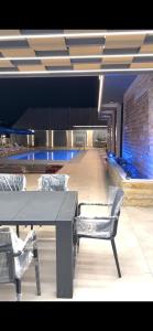 a room with a table and chairs and a pool at Green Vista in Māḩiş +9 photos