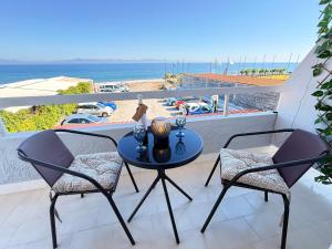 a table on a balcony with a view of the beach at Beachfront Studio with Panoramic Sea View 2 in Ialysos