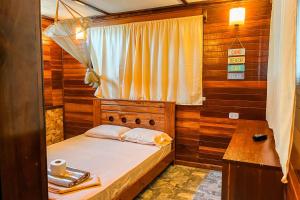 a small bedroom with a bed and a window at Casa Lobos in Lobitos