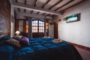 a large blue bed in a room with a window at La Llama Negra in Tilcara