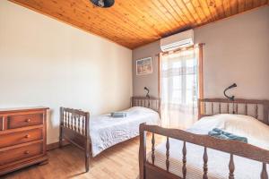 two twin beds in a bedroom with a wooden ceiling at Chez Catherine Et Gérard in Tonnay-Charente