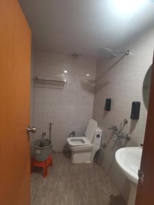 a bathroom with a toilet and a sink at Tira Hotel and Cafe in Rudraprayāg