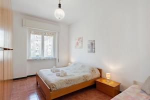 a white bedroom with a bed and a window at Isonzo Holiday Home - 2 bedrooms in Loano