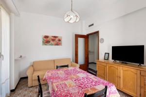 a living room with a table and a flat screen tv at Isonzo Holiday Home - 2 bedrooms in Loano