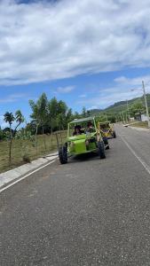 ein grüner Jeep fährt eine Straße entlang in der Unterkunft Frailin Merete in San Felipe de Puerto Plata