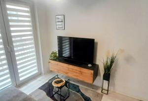 a living room with a flat screen tv on a wall at Apartament Amelia in Zamość