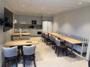 a room with wooden tables and chairs and a kitchen at Uncle Joe's in Visby