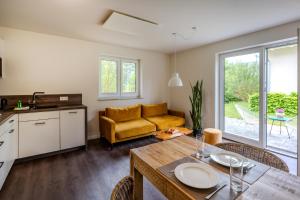 a living room with a table and a yellow couch at Dünenquartier Apartment 24 in Zingst