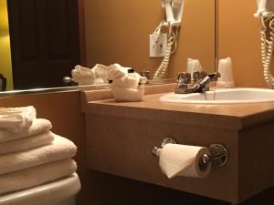 La salle de bains est pourvue d'un lavabo, d'un miroir et de serviettes. dans l'établissement Motel Cofotel, à Saint-Siméon