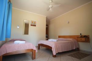 a room with two beds with pink sheets and a mirror at Hotel Fazenda 7 Belo in Socorro +57 photos