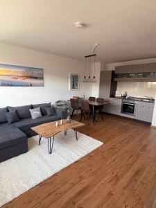 a living room with a blue couch and a table at Ferienwohnung Fortuna in Borkum