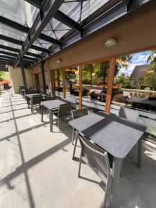 an outdoor patio with tables and chairs and windows at Delita Cozy Hotel in Druskininkai