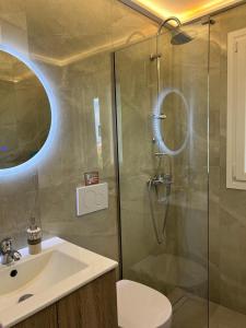 a bathroom with a shower with a sink and a toilet at Vista Mare Maisonette in Ipsos +23 photos