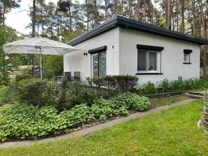 a small white house with an umbrella in front of it at Ferienhaus Stefanie in Plodda