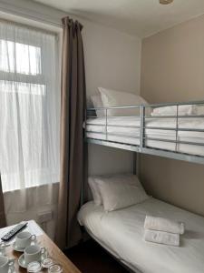 a small room with a bunk bed and a window at Stay at 25 in Blackpool