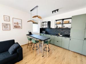 a kitchen with a table and chairs and a couch at Small Garden Apartman in Sárvár