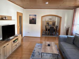 a living room with a couch and a tv and a table at Ferienwohnung Felsenidyll in Bundenthal