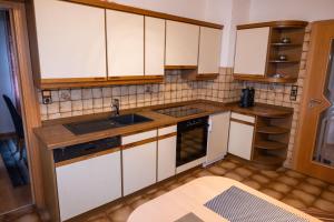 a small kitchen with white cabinets and a sink at Ferienwohnung Felsenidyll in Bundenthal