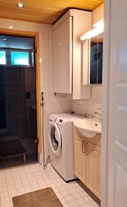 a bathroom with a washing machine and a sink at Seastar 101 in Kalajoki