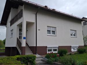 a white house with a staircase in front of it at Apartman Martina in Gospić